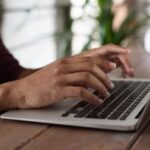 person using macbook 300x203.jpg